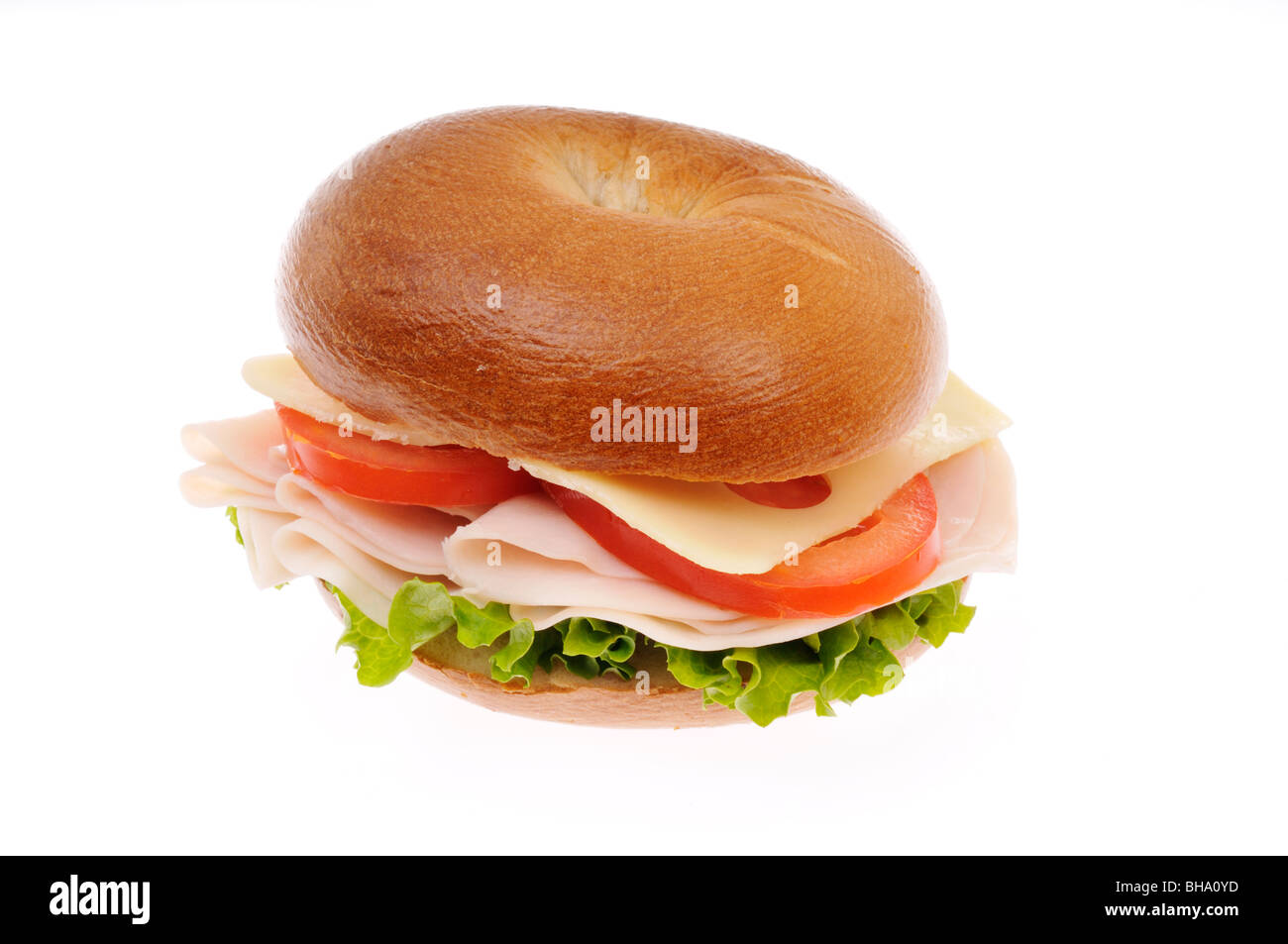 Turkey and swiss cheese sandwich on a bagel with lettuce and tomato on a white background. Cut out Stock Photo