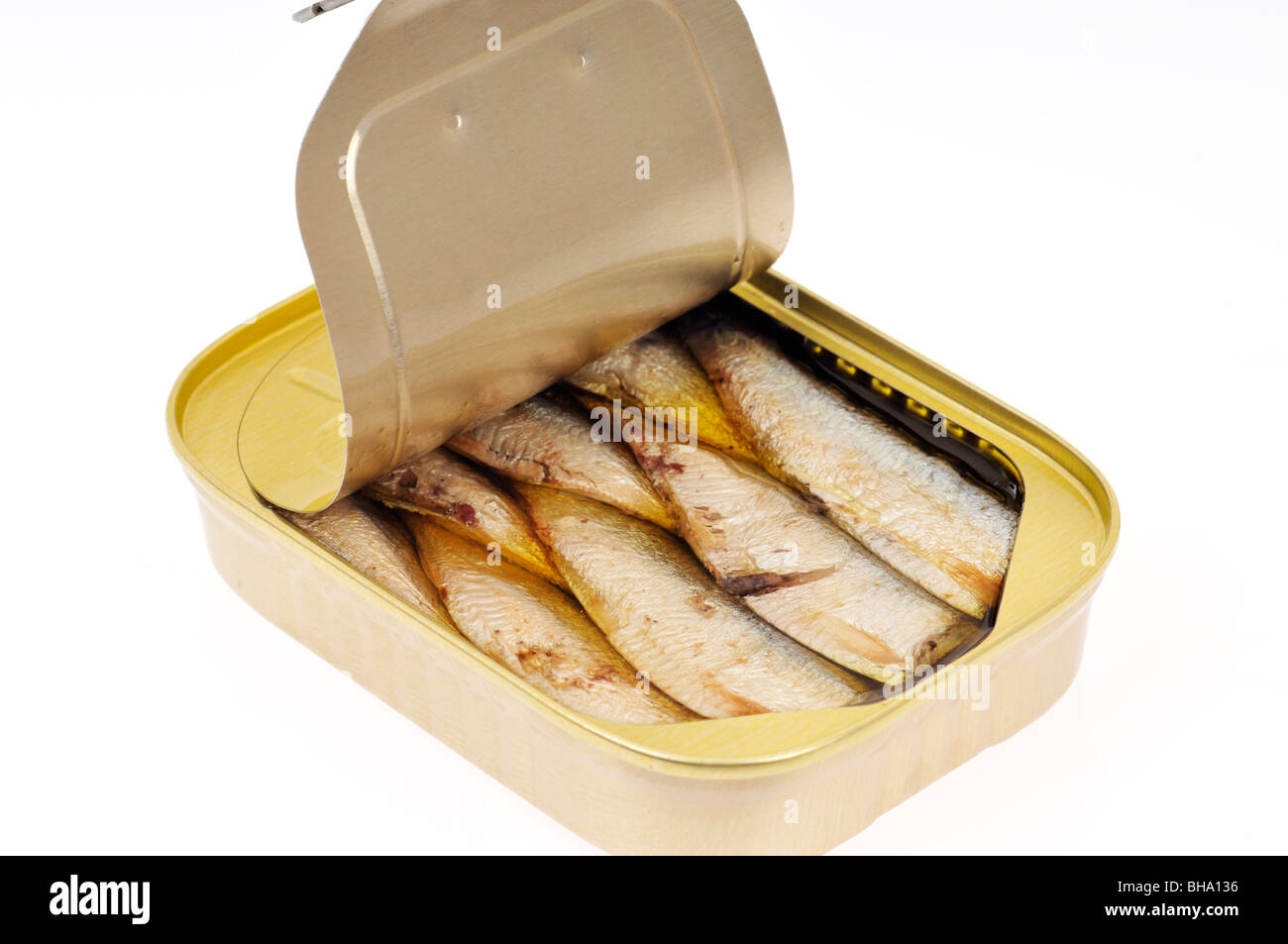 An open pull tab tin of sardines packed in oil on white background, cut ...