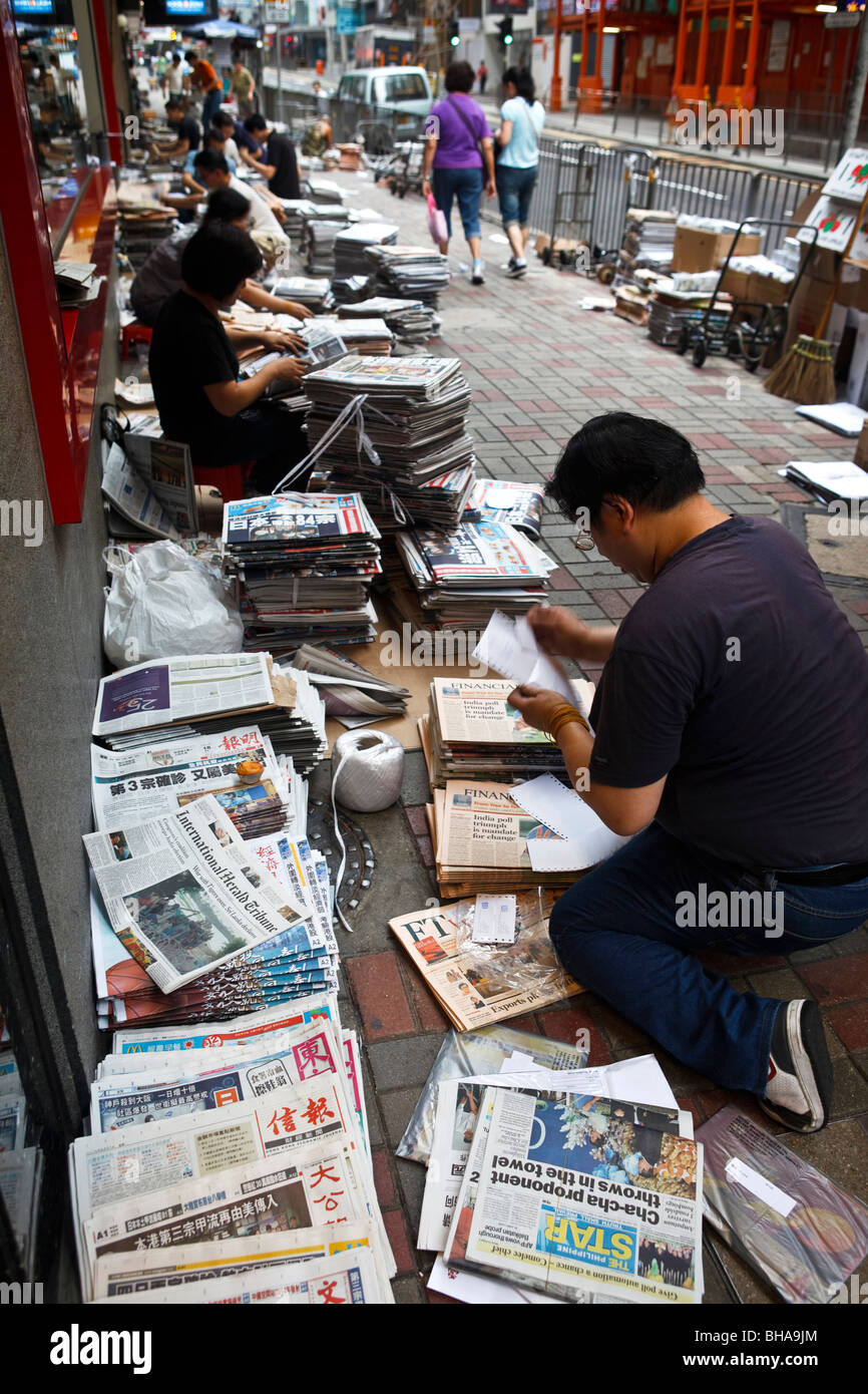 People stack and pack newspapers as part of the delivery and