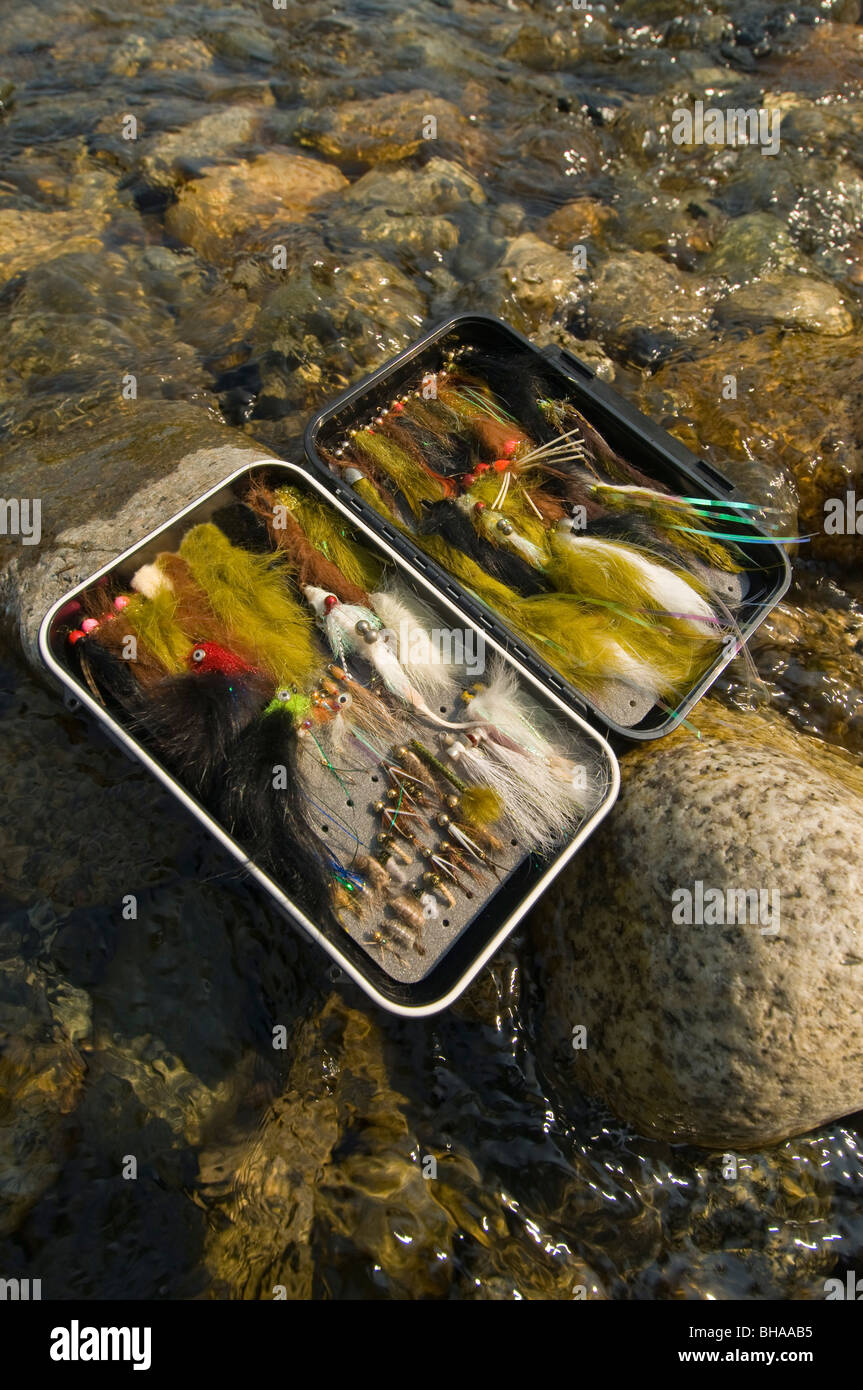 Still life of a fly fisherman's fly box on rocks in Montana Creek