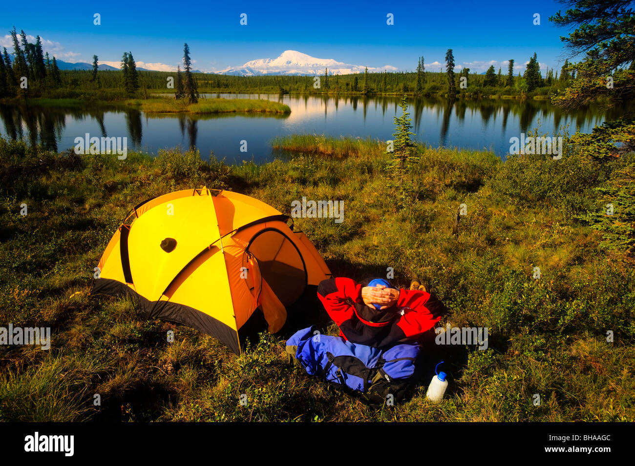 Backpacker enjoys the view of Mount Sanford from his campsite, Wrangell Saint Elias National Park, Southcentral Alaska, Summer Stock Photo