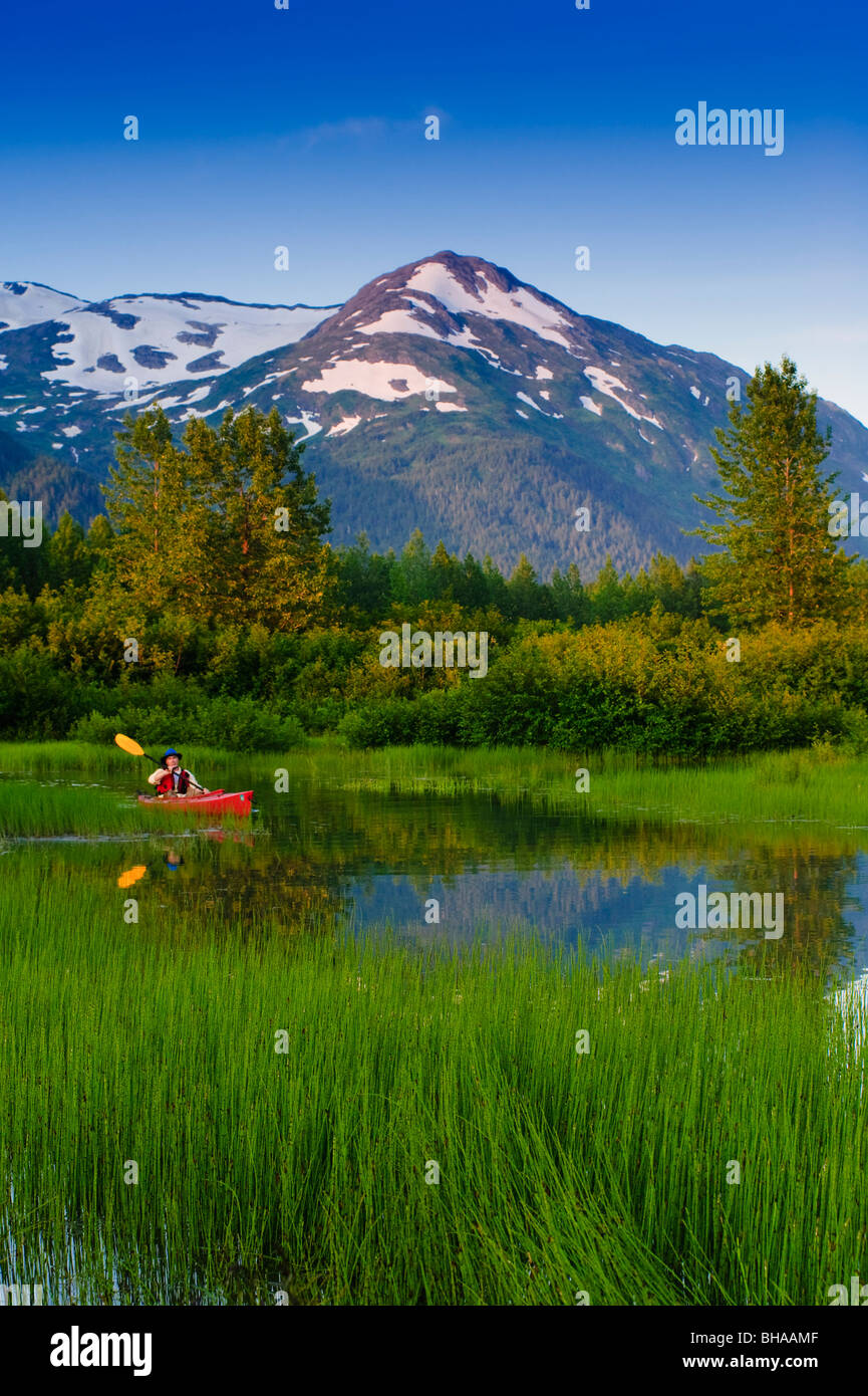 Man in a kayak paddling in a small lake in Portage Valley, Southcentral, Alaska, Summer Stock Photo