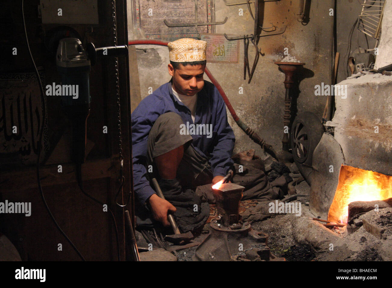 Sanaa, Yemen. A young man forges metal in the furnace, the traditional way. Chewing qat and at night. Stock Photo