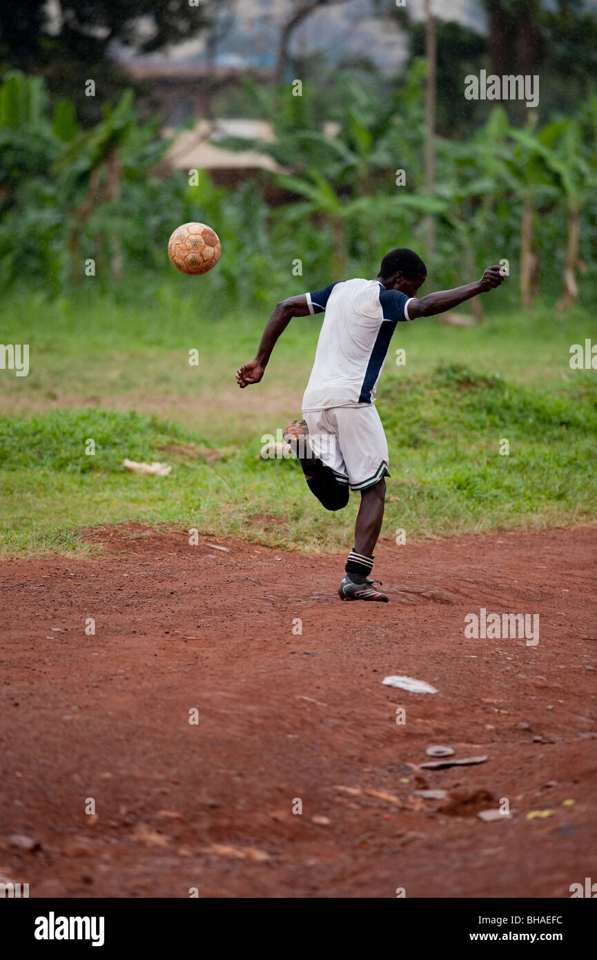 Young man kicking football into the air behind his back in Kampala Uganda Stock Photo