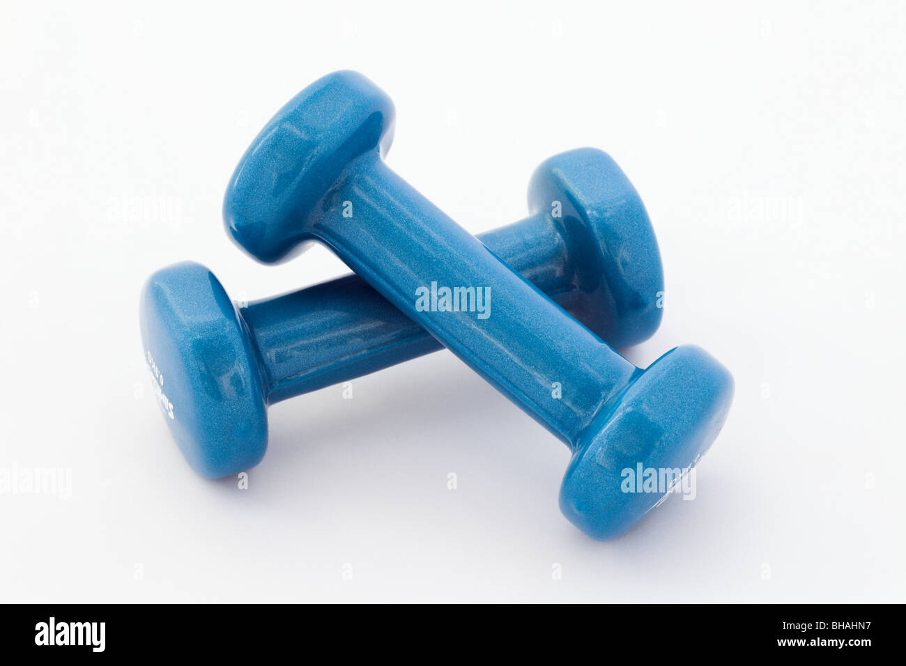 Pair of small blue dumbbell exercise weights cut out and isolated on a ...