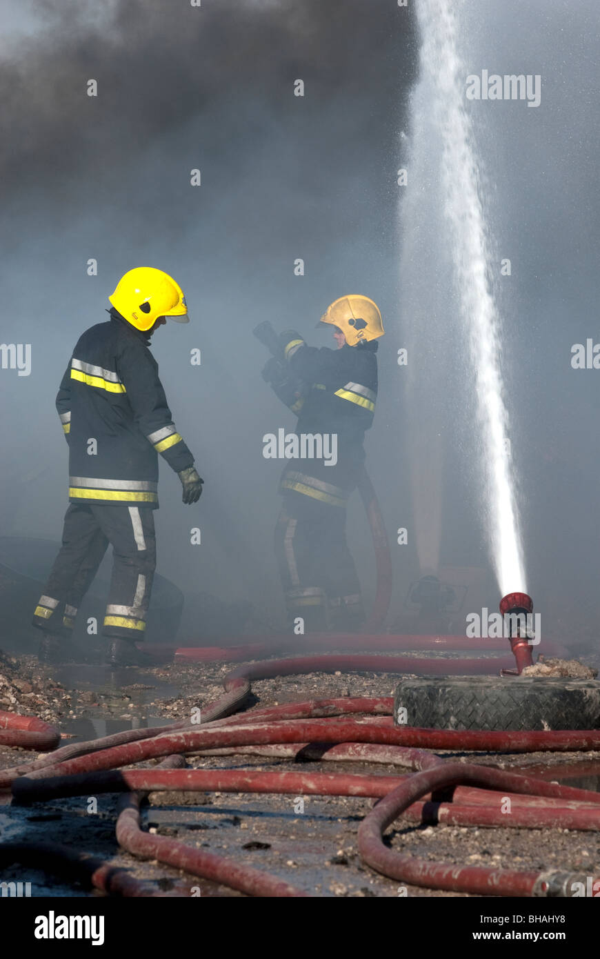 Firemen with multiple ground monitors in use Stock Photo