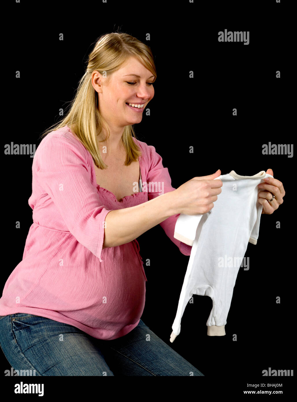 Pregnant Woman holding baby clothes Stock Photo