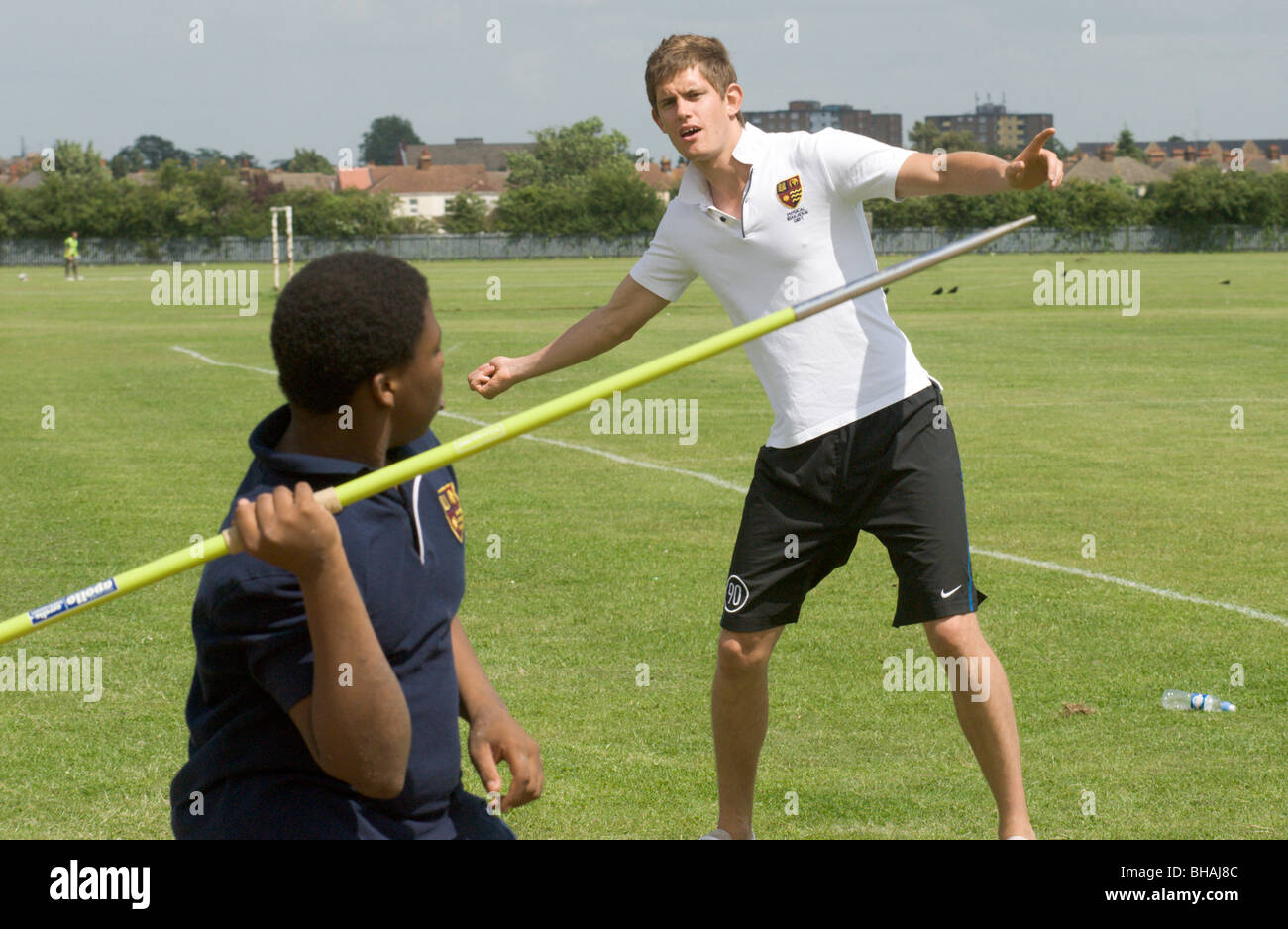 PE instructor shows a school child how to throw a Javelin UK Stock