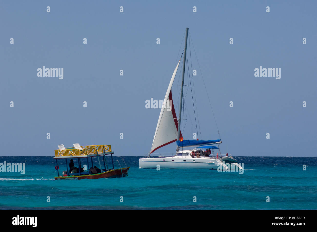 A catamaran passing a glass bottom boat off the west coast of Barbados