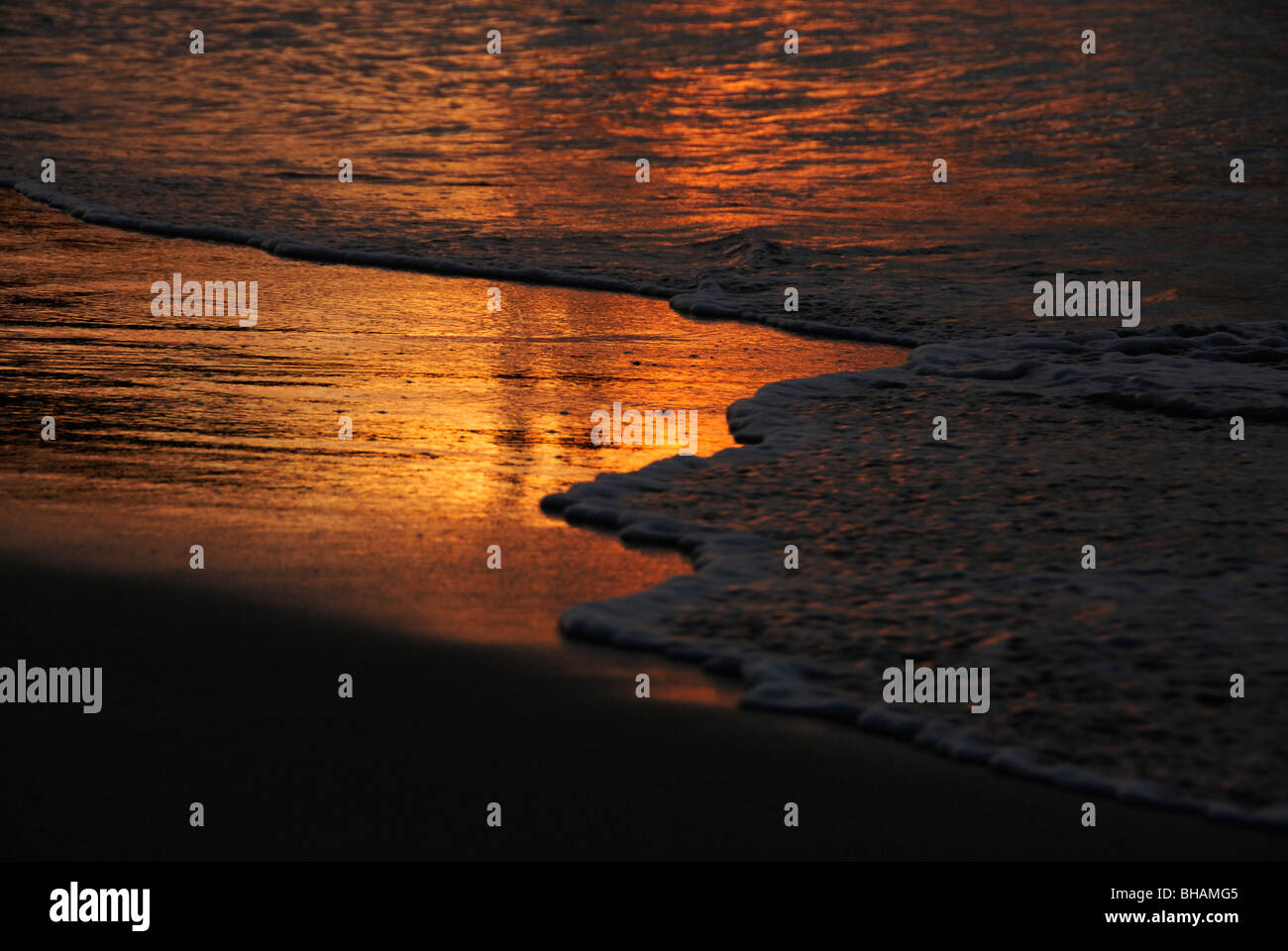 Sunset in the gentle surf an the Tamarind Beach Hotel, Canouan Island ...