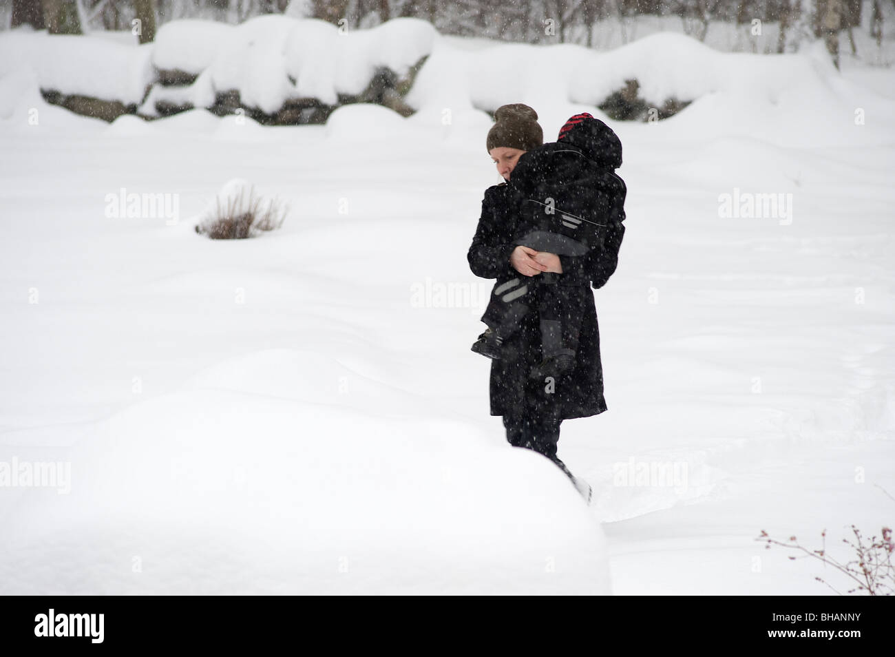 woman and child in snow, Sweden Stock Photo