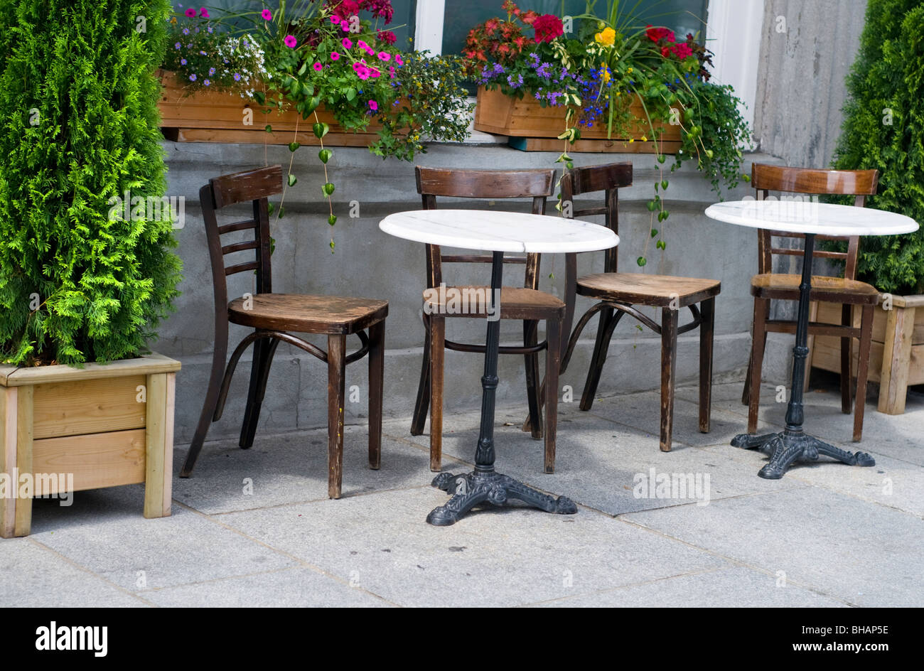 Tables and chairs on the pavement outside a cafe in the old town district of Montreal in Canada Stock Photo