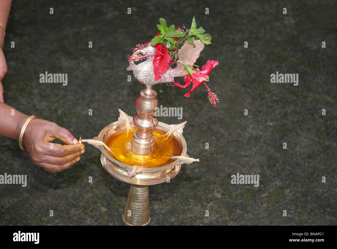Lighting the Divine Lamp decorated with flowers in Tamil Pongala