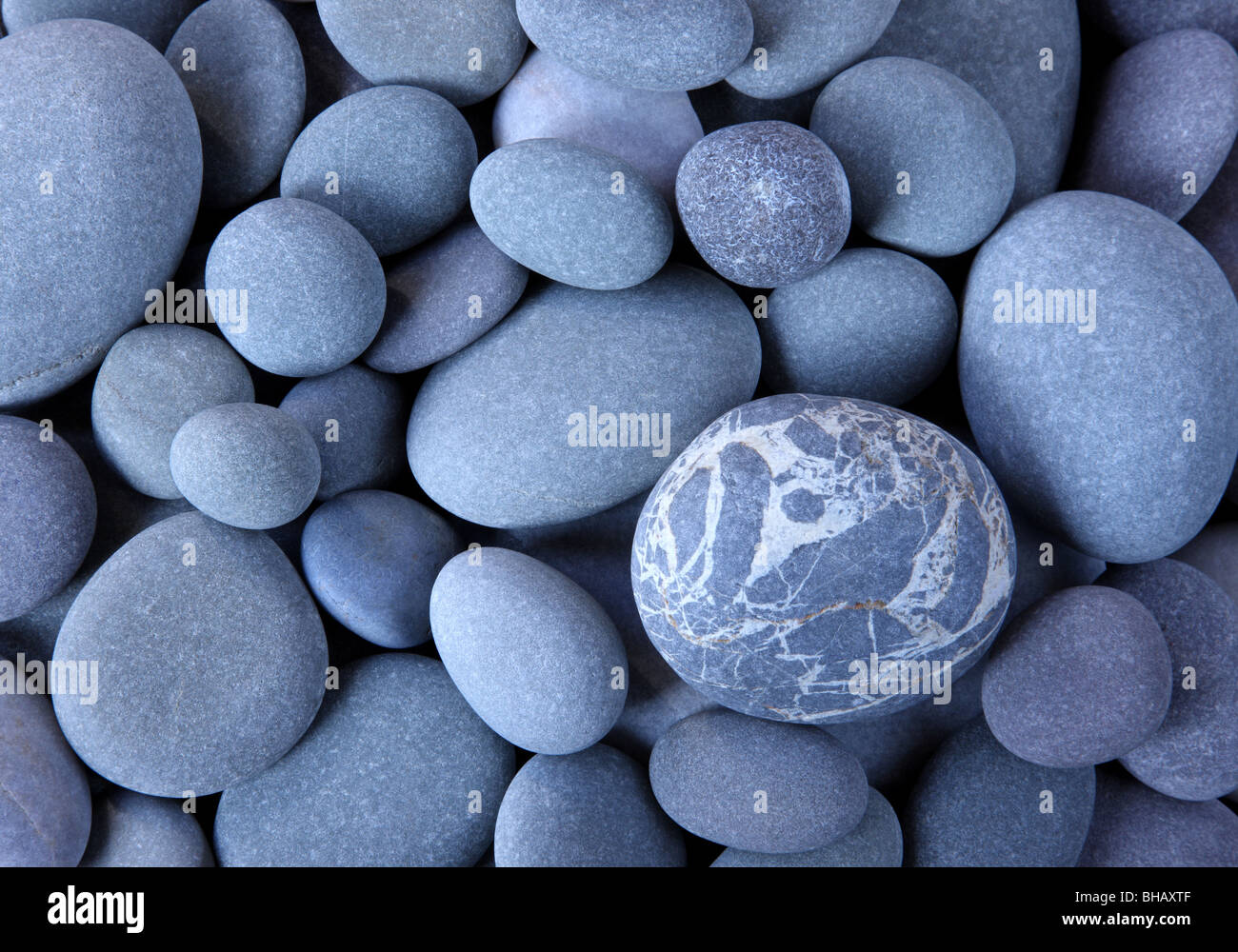 Close up of smooth granite pebbles on Hurlestone beach, Somerset, England filling frame. Stock Photo