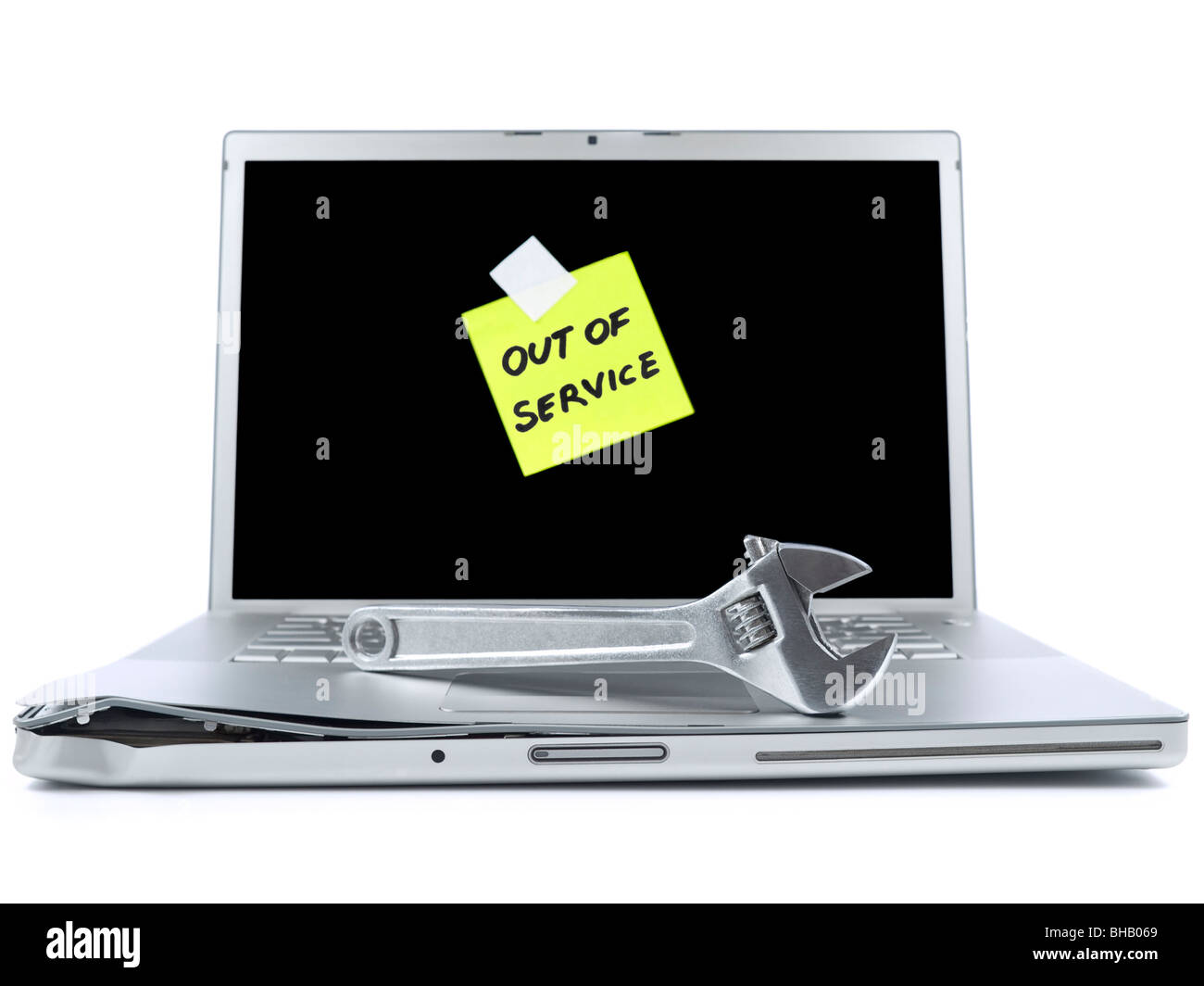 Damaged laptop with a post-it saying Out of Service and a spanner over it. Isolated on white. Stock Photo