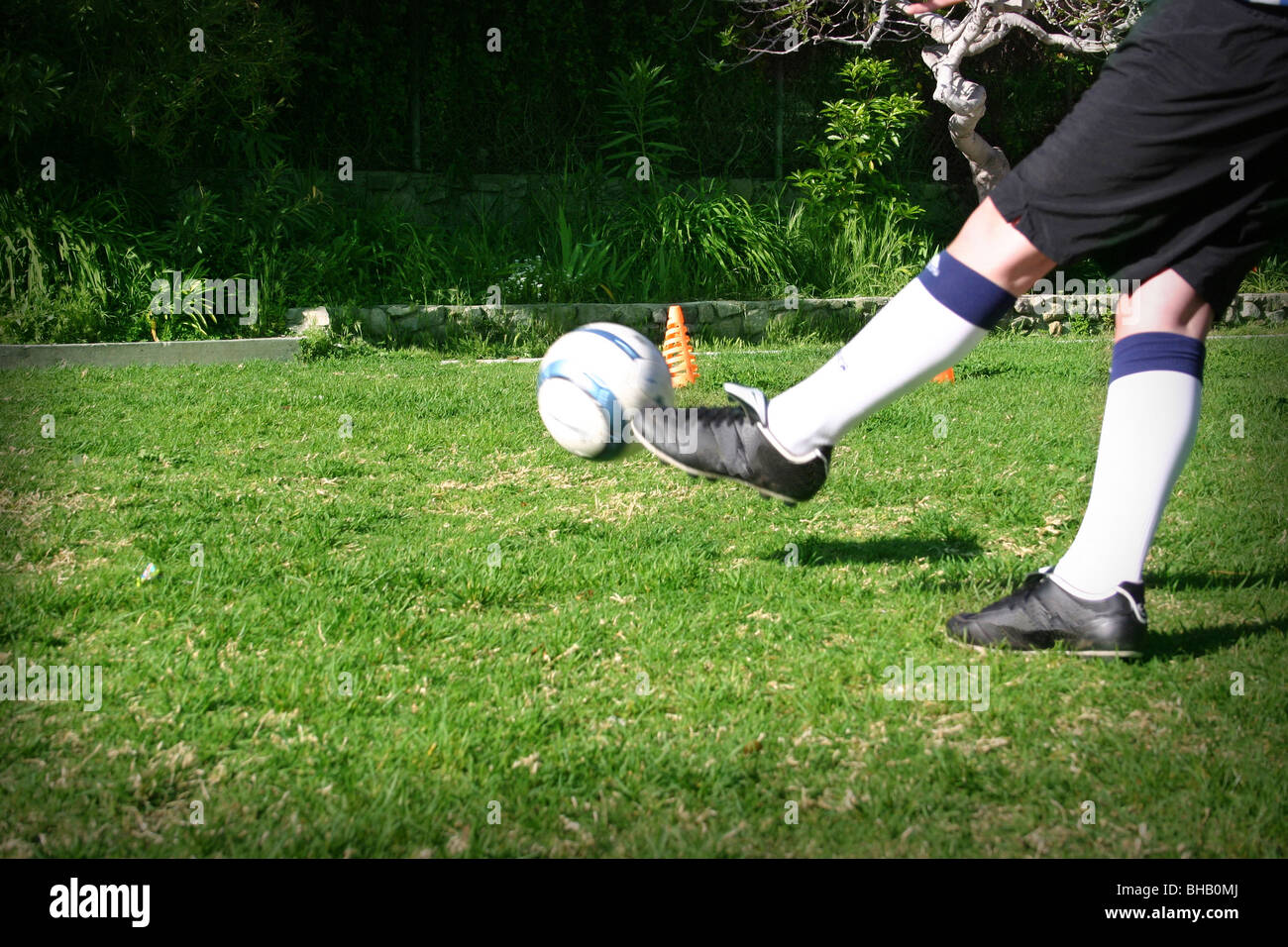 Football being kicked by youth player Stock Photo Alamy