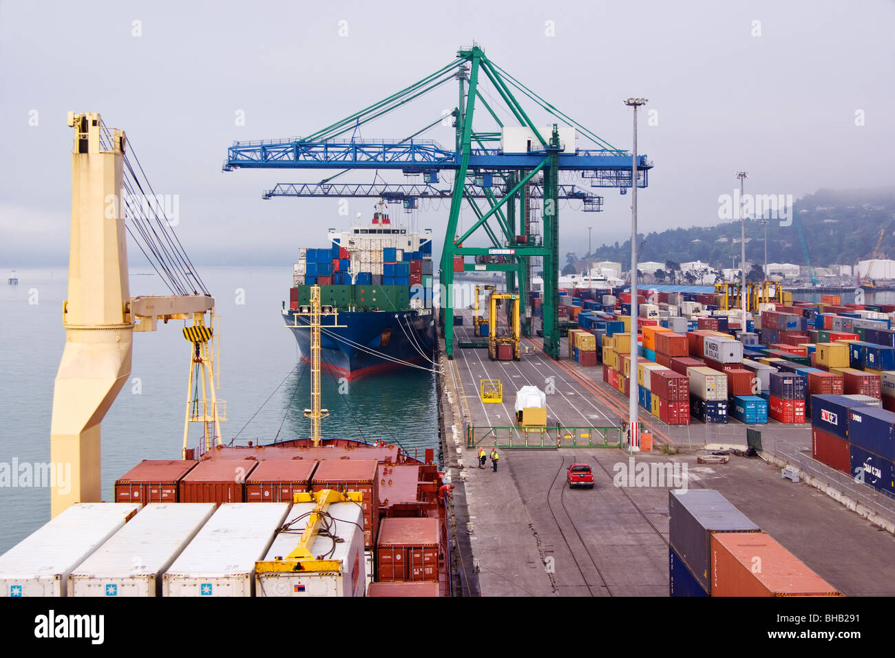 View of container terminal with ships, cranes and container yard at Lyttelton, New Zealand. Stock Photo