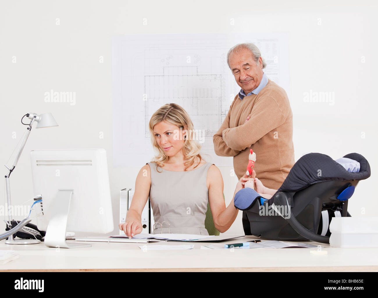 Woman with baby, boss watching her. Stock Photo