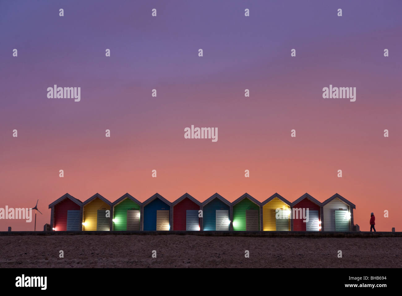 Colourful, illuminated beach huts at sunset on Blyth Beach, Northumberland, United Kingdom Stock Photo