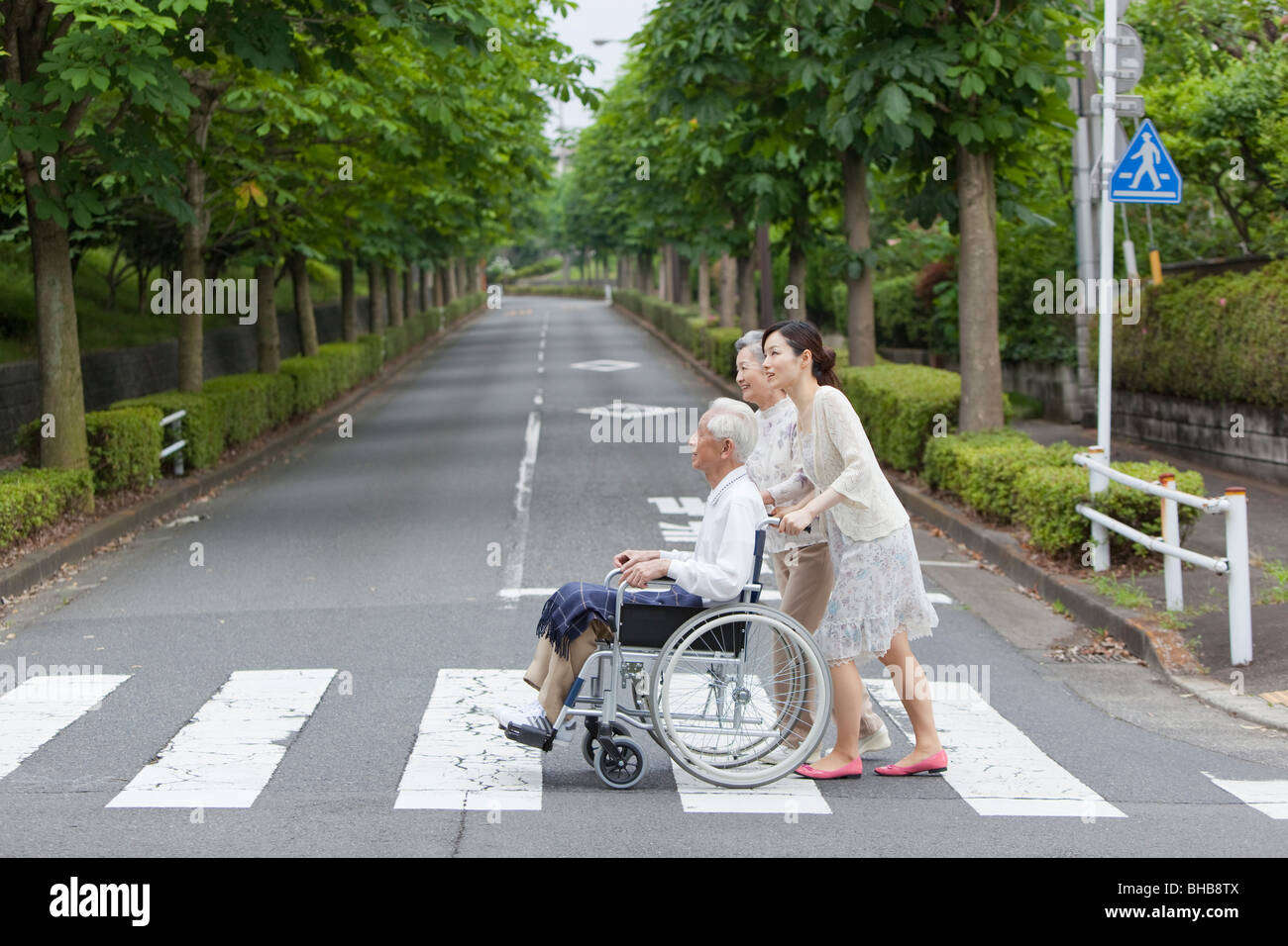 Japan, Tokyo Prefecture, Woman pushing senior man in wheelchair