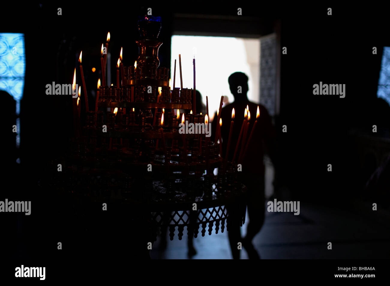 Candles and man shadow in Greek orthodox church Stock Photo