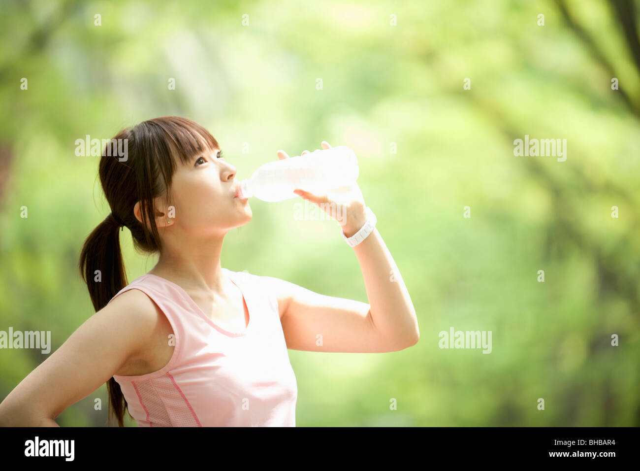 Japan, Osaka Prefecture, Woman drinking water, side view Stock Photo