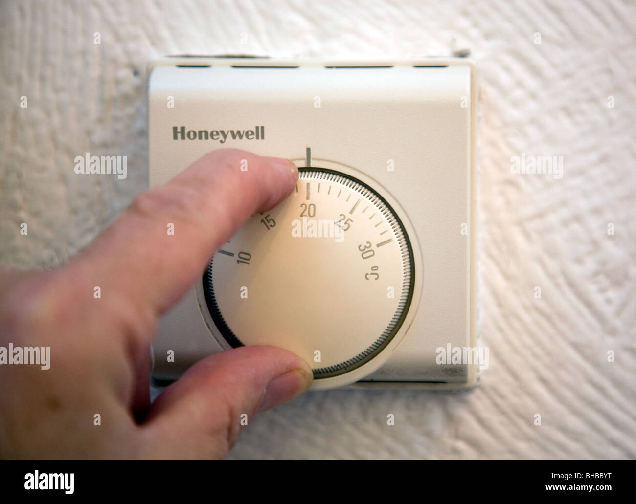 Turning down central heating thermostat, London Stock Photo Alamy
