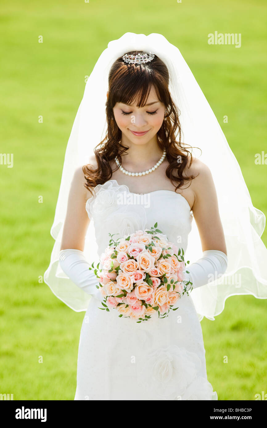 a smiling Japanese bride holding bouquet of flowers Stock Photo - Alamy