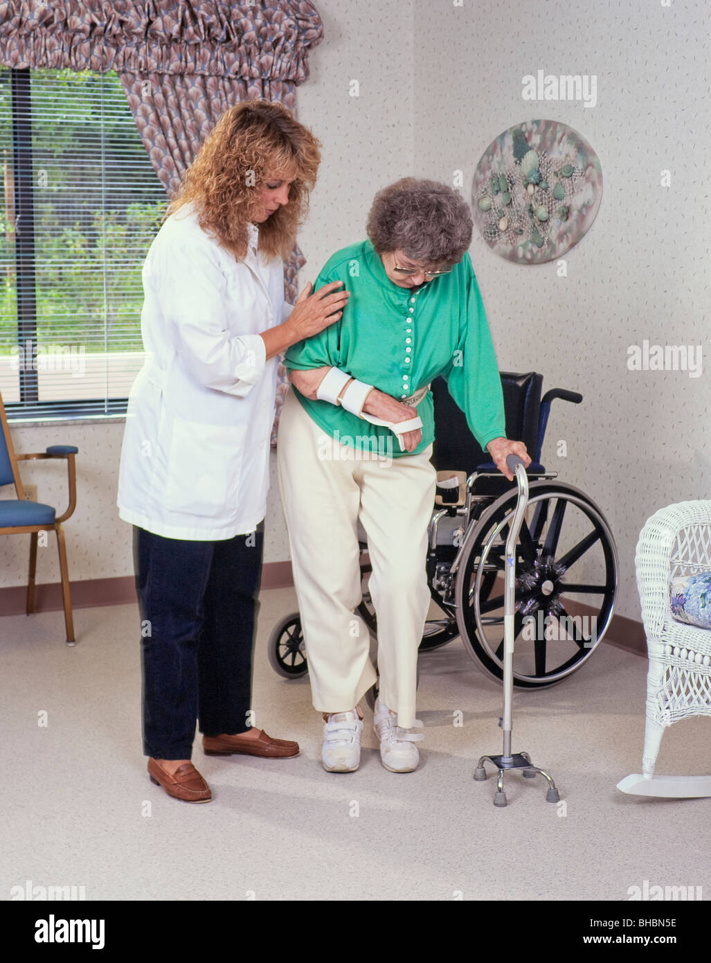 Senior aged woman with walker receiving assistance from physical therapist Stock Photo