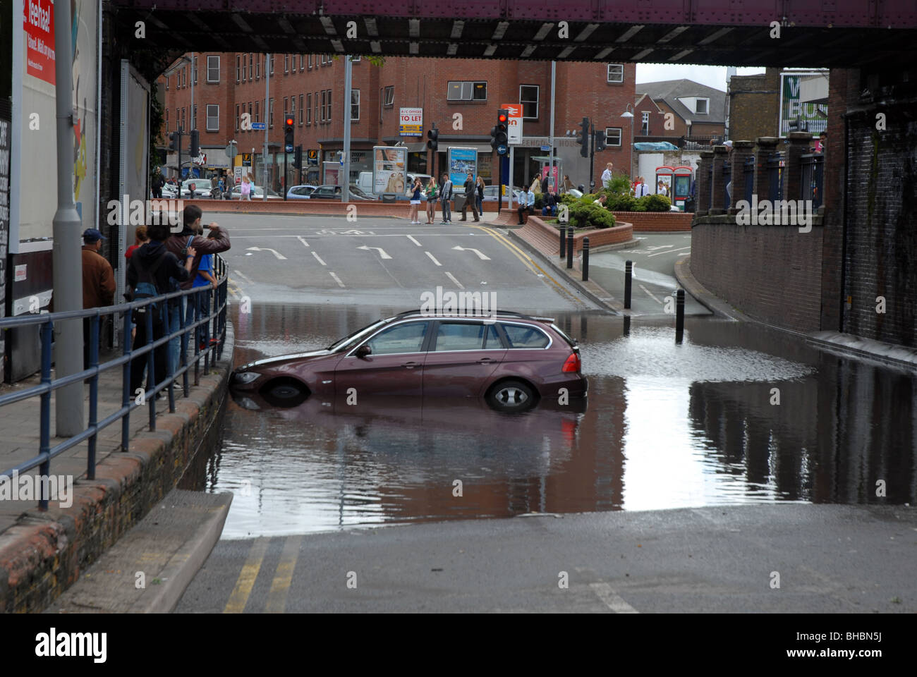 BMW car floating in flood water after heavy rain and blocked drains caused  it to get stuck under railway bridge in Kingston, SW London Stock Photo -  Alamy