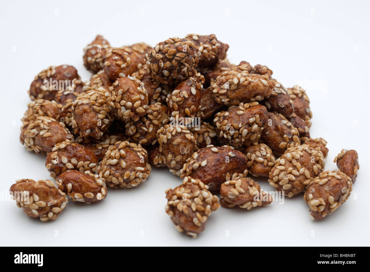 Pile of caramel coated roasted peanuts sprinkled with sesame seeds Stock Photo
