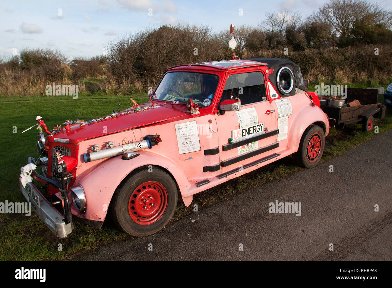 Pink ecological car made of various makers parts, running on Vegetable