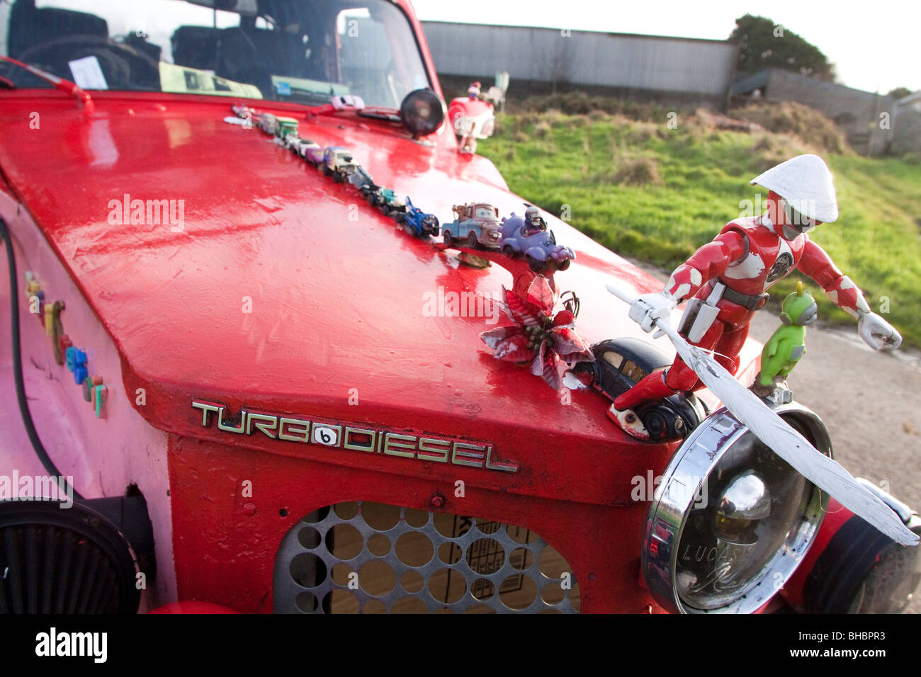 Pink ecological car made of various makers parts, running on Vegetable
