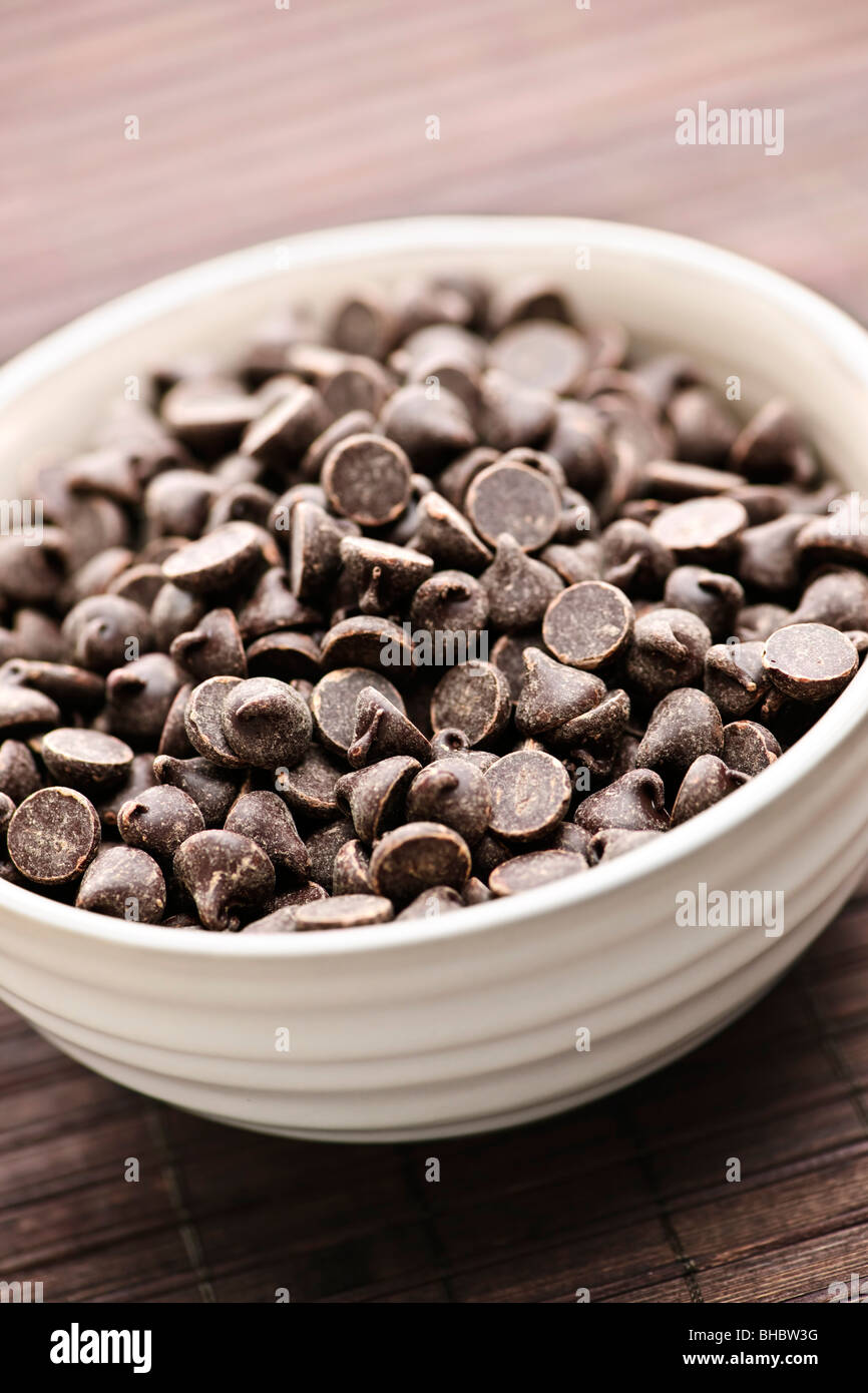 White bowl of sweet dark chocolate chips Stock Photo