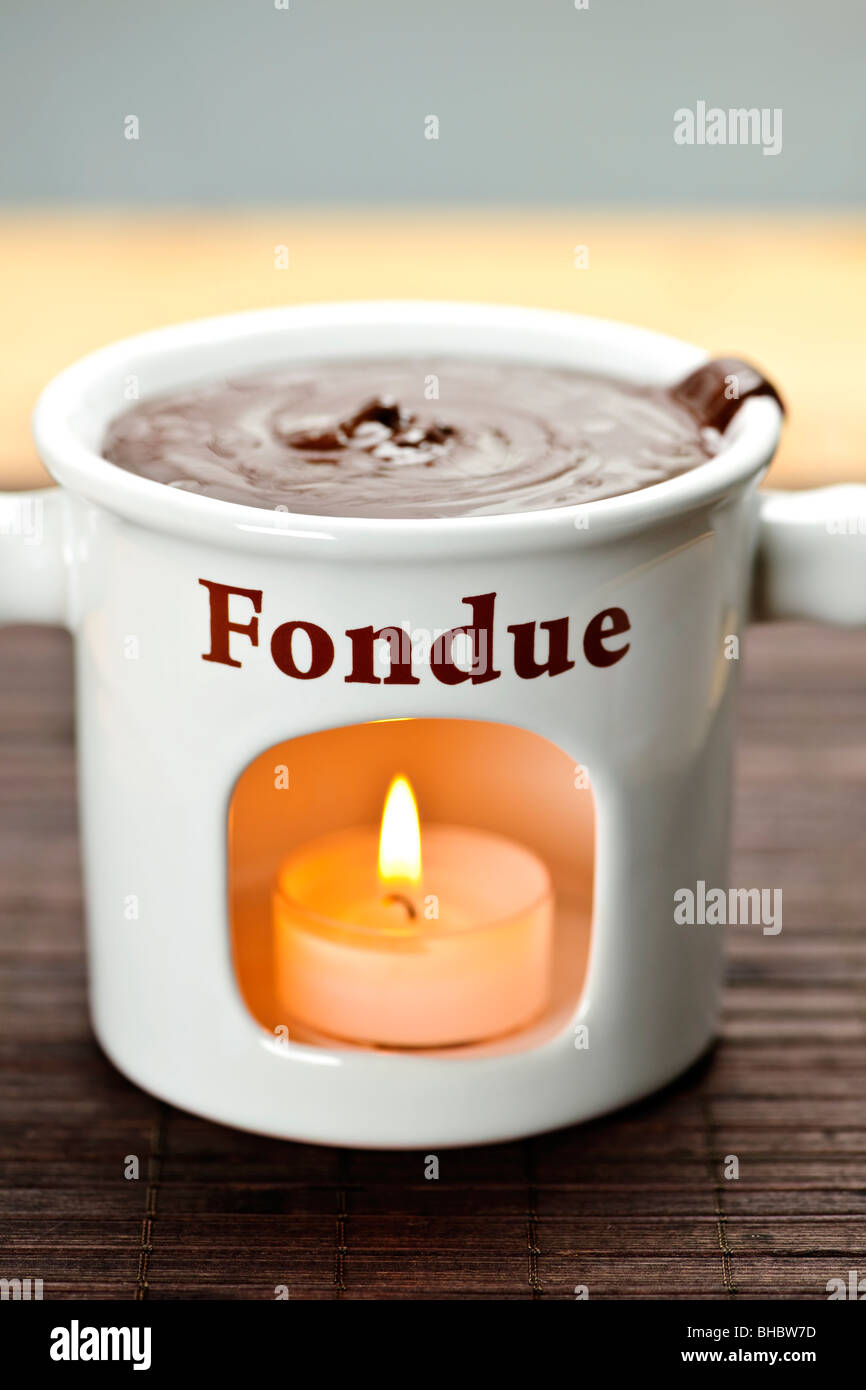 Delicious melted chocolate in ceramic fondue pot Stock Photo