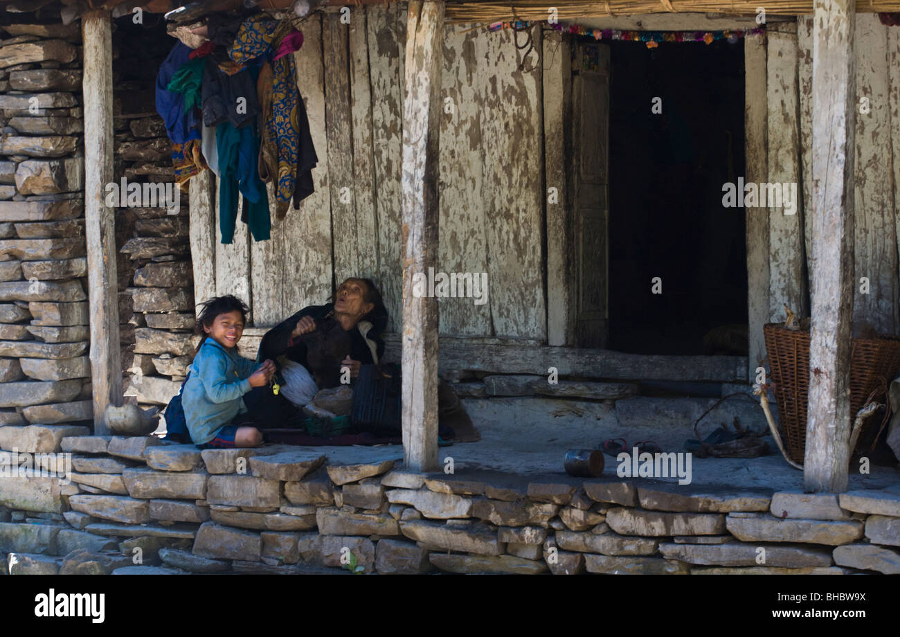 A NEPALI GRANDMOTHER and GRANDCHILD on their front porch - AROUND MANASLU TREK, NEPAL Stock Photo