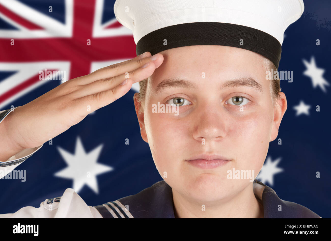young female sailor saluting in front of australian flag Stock Photo