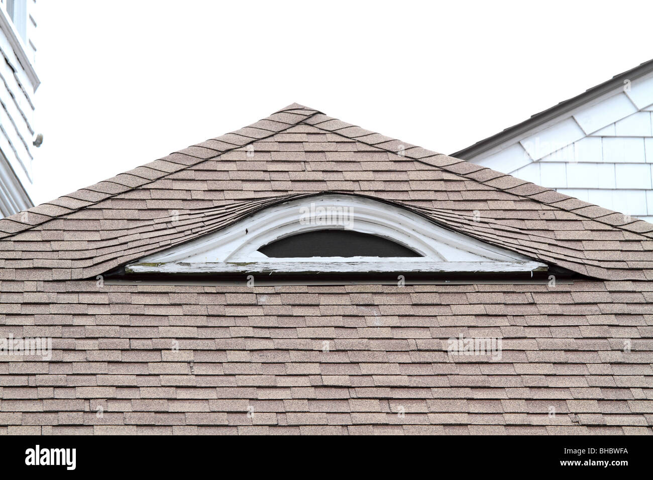 Eyebrow dormer windows show the architecture of an old house. Stock Photo