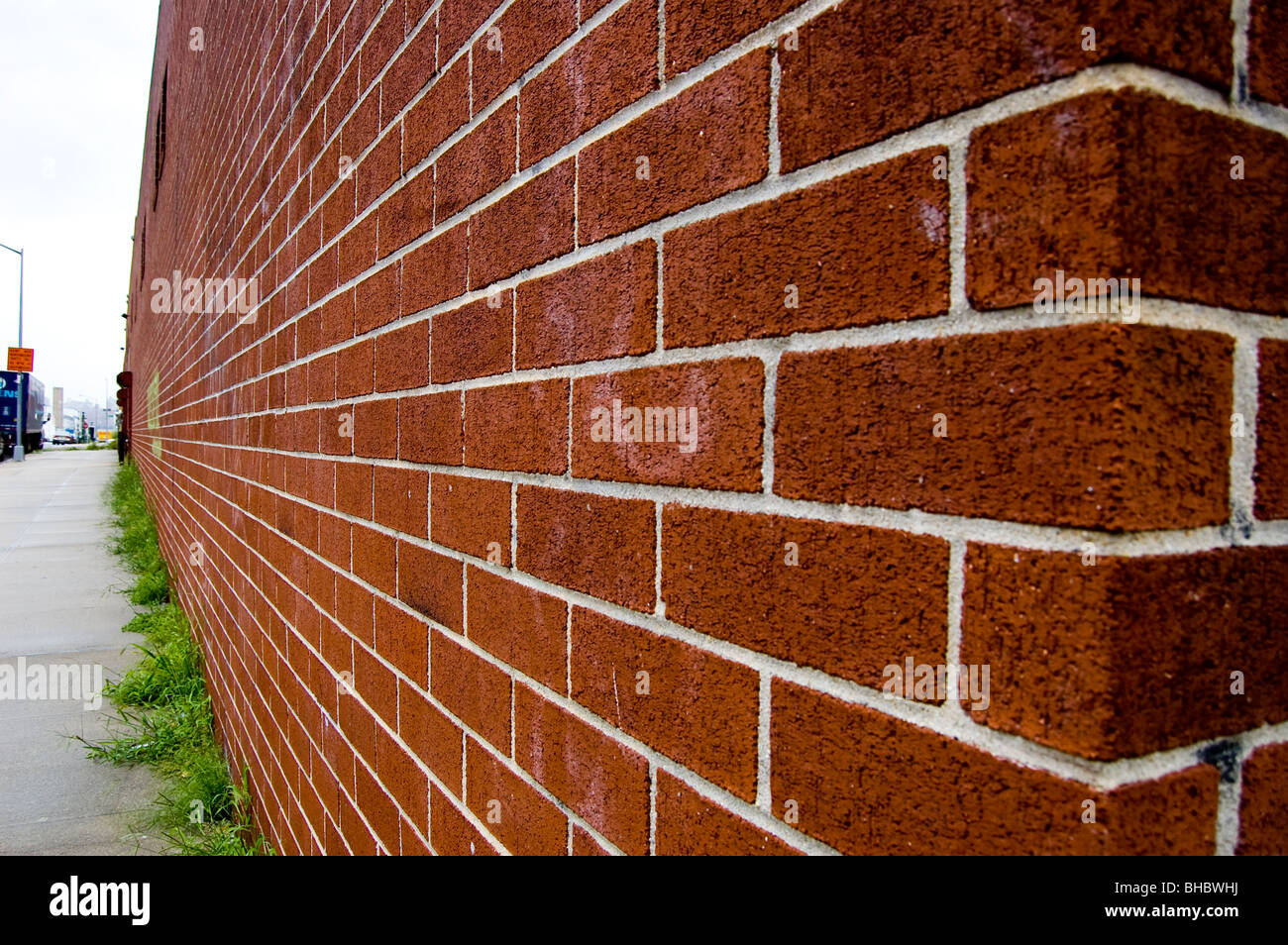The corner and wall of a long brick wall as seen in perspective. Stock Photo