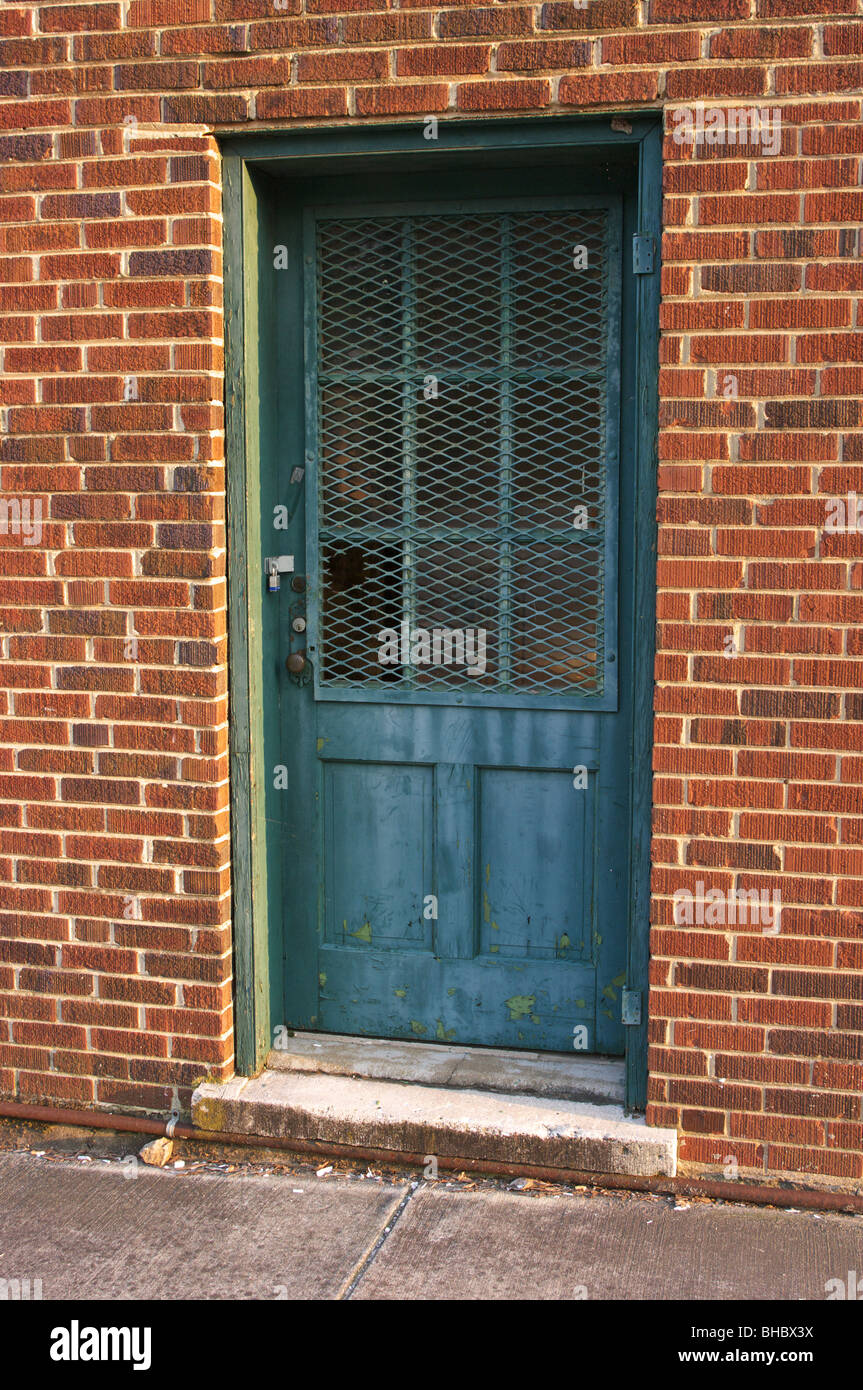 Old security door on a red brick building Stock Photo