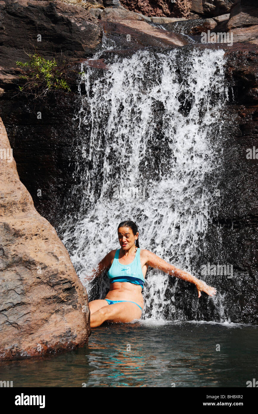 Female hiker cooling of under waterfall in mountains of Gran Canaria in the Canary islands Stock Photo