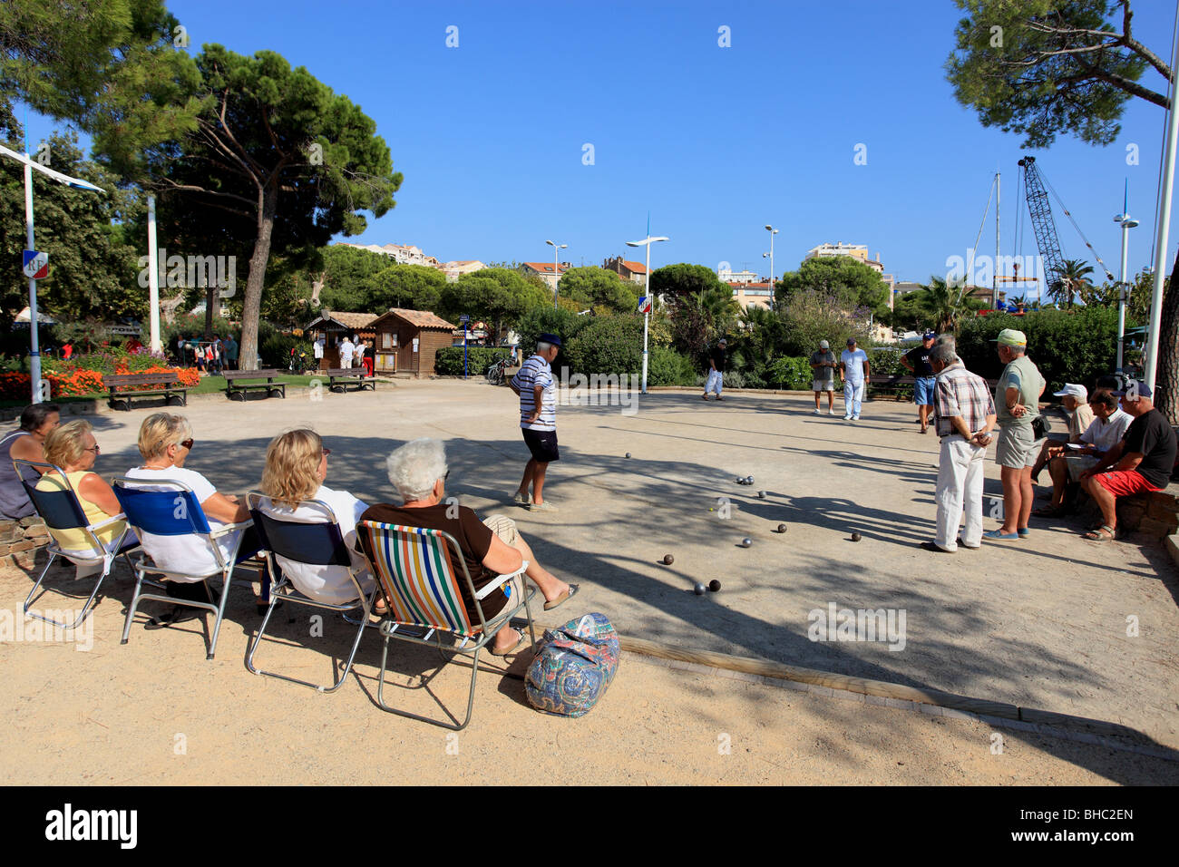 Women watching men playing boules in Sainte Maxime during holidays vacation. Boules (steel balls) is a typical game in Provence Stock Photo