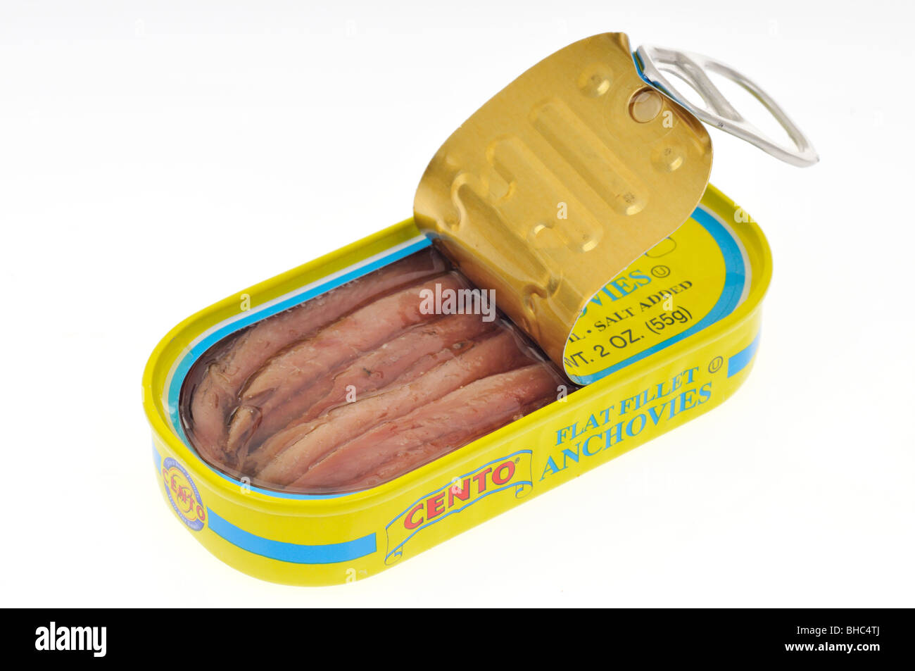 Fillets of anchovies in an open tin on white background. Stock Photo