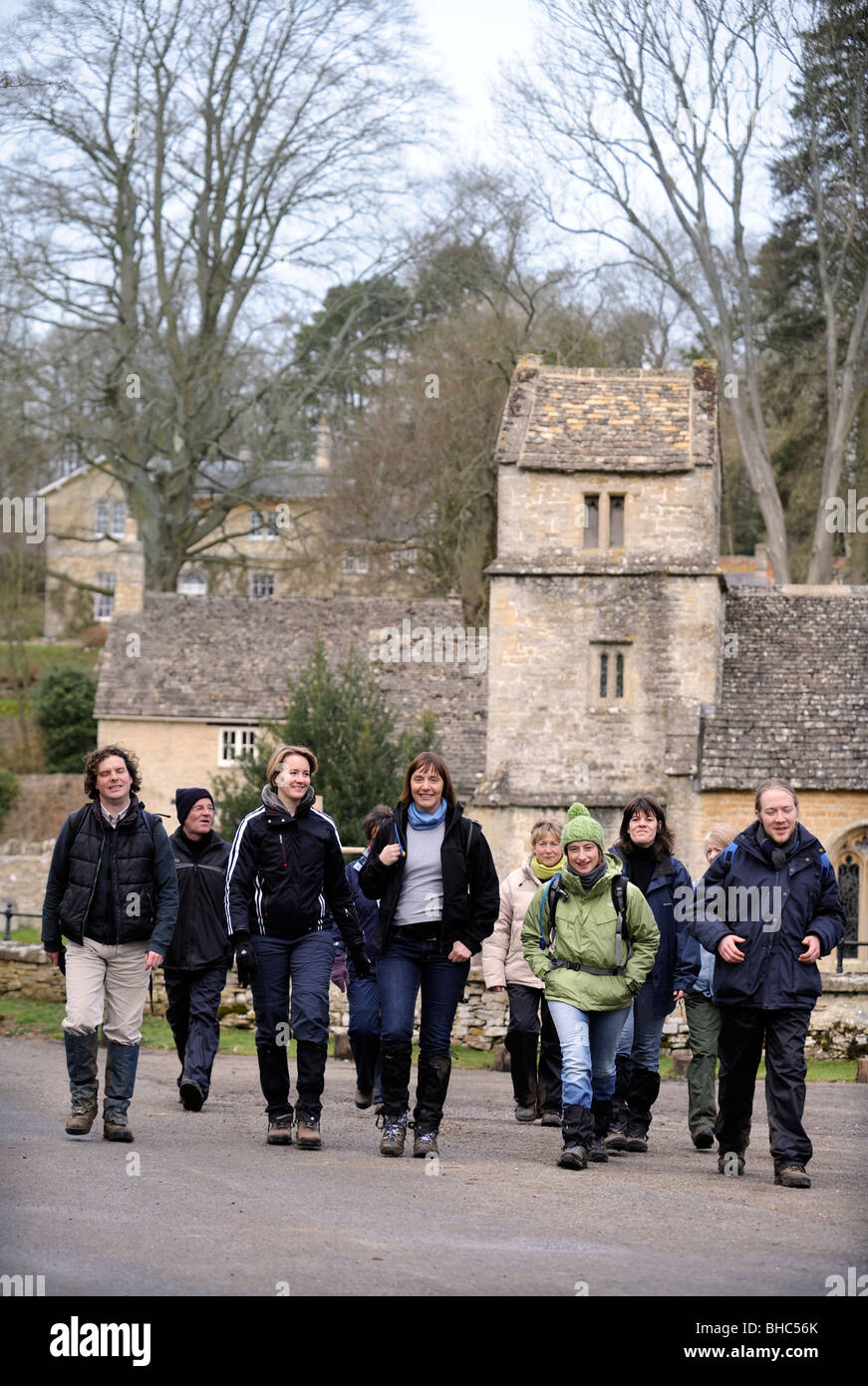 A group of walkers enjoy a mid morning stop by St Margaret's Church, Bagendon Gloucestershire UK Stock Photo