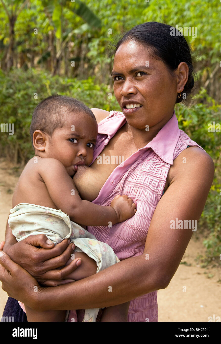 Mother breast feeding her baby at now peaceful Elcolbere village Alieu region EastTimor Stock Photo