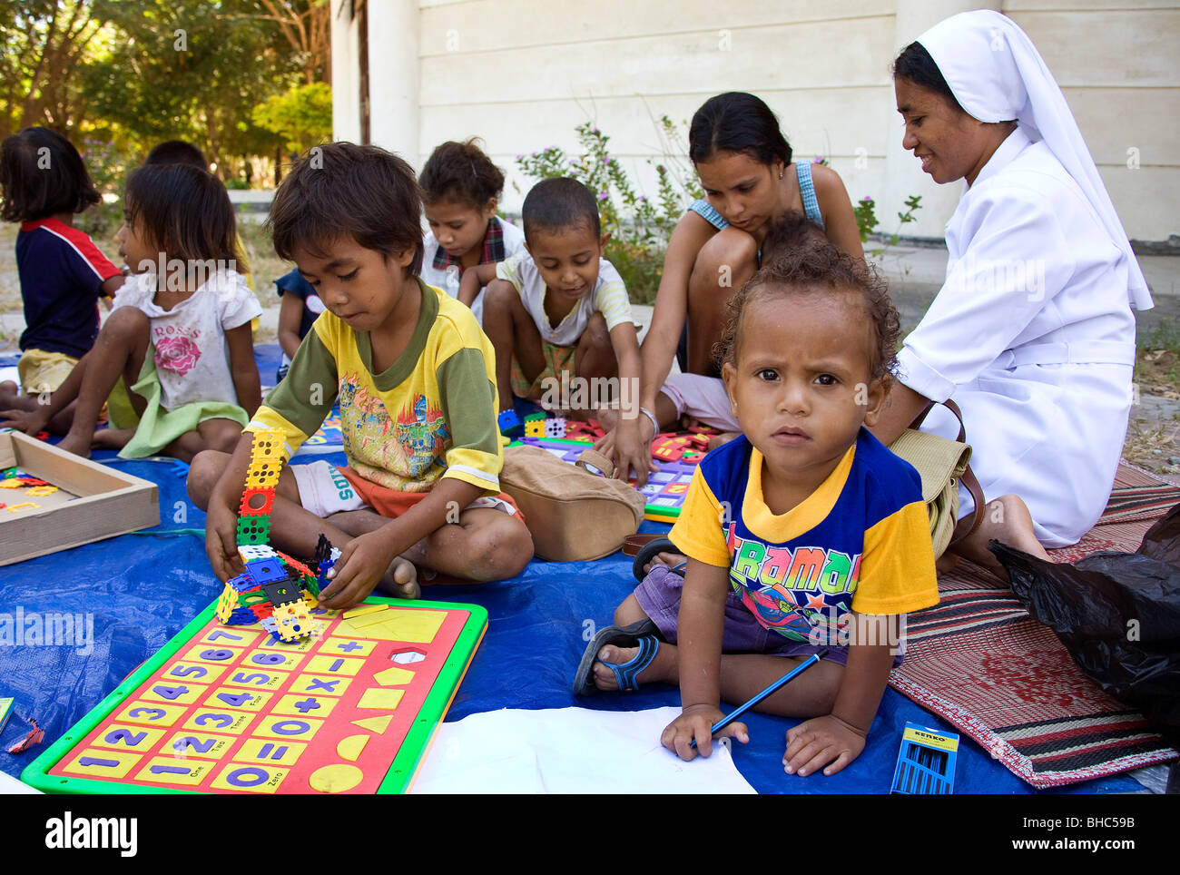Catholic nun helps children's learning at IDP camp in Dili East Timor part of Oxfam health and learning program Stock Photo