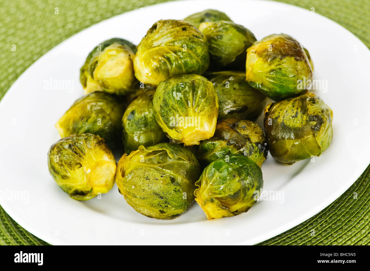 Plate of roasted green brussels sprouts on placemat Stock Photo