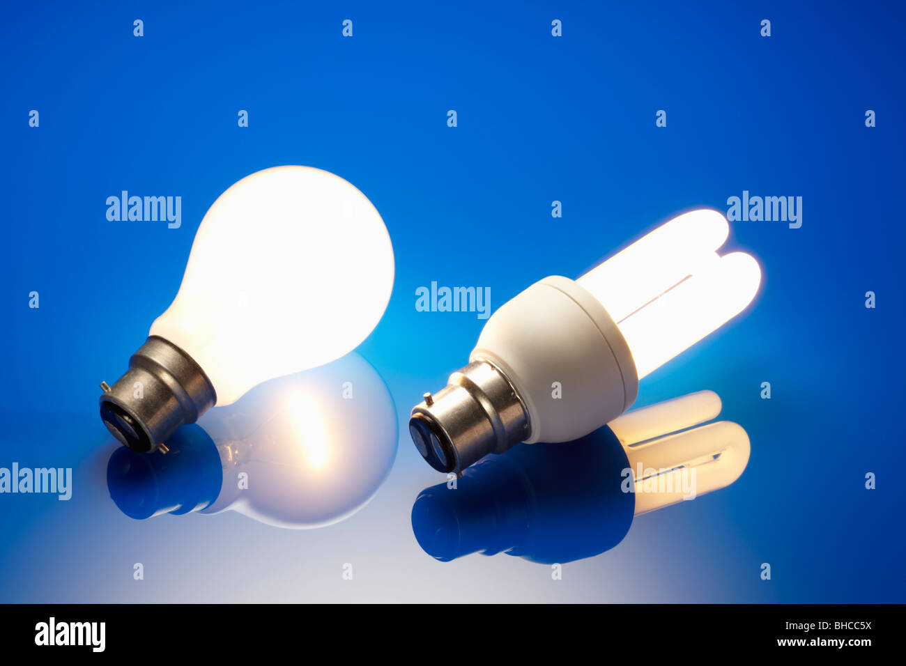 Energy Saving Light Bulb and Standard Light Bulb Illuminated Stock Photo