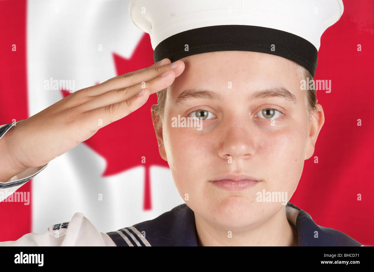 young female sailor saluting in front of canadian flag Stock Photo