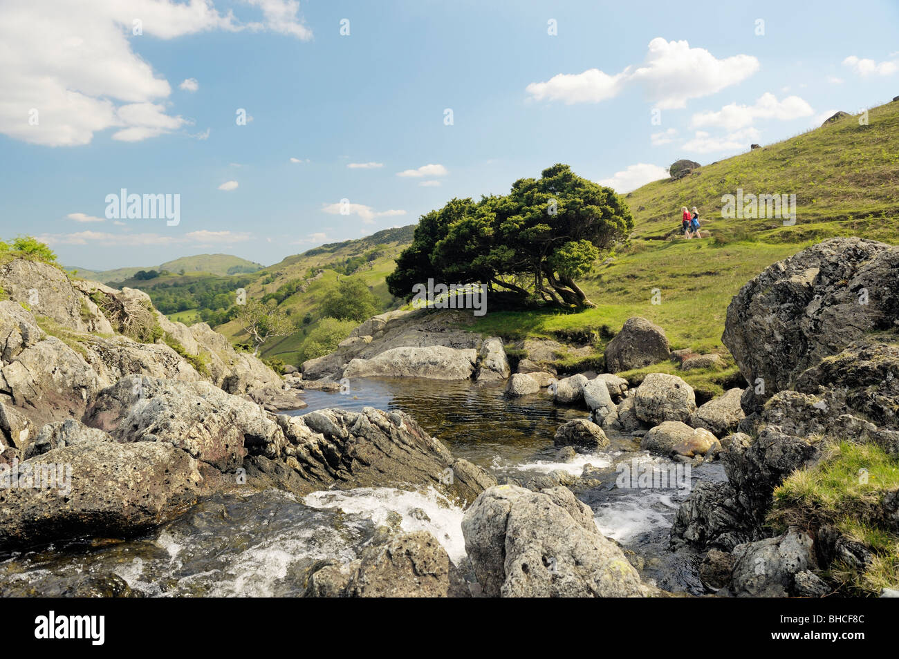 Lake District National Park, Cumbria, England. Sour Milk Gill tumbles down Easedale to Grasmere valley. Walkers on path Stock Photo